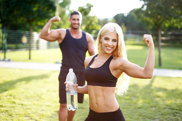 Fit couple in nature with bottle of water — Stock Photo, Image