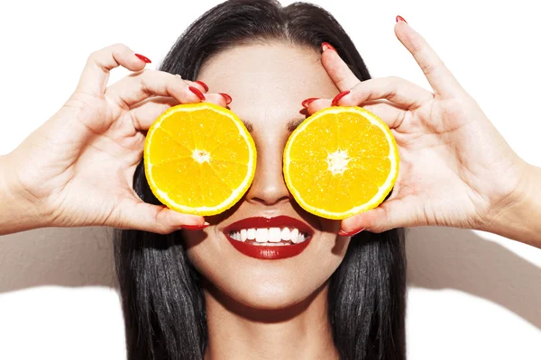 Mulher segurando anéis de laranja nos olhos — Fotografia de Stock