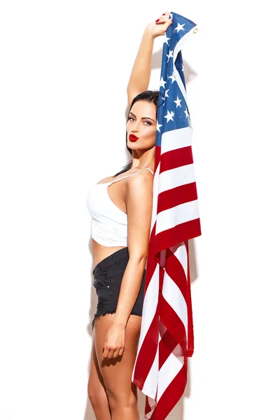 Sexy woman holding USA flag at white wall — Stock Photo, Image