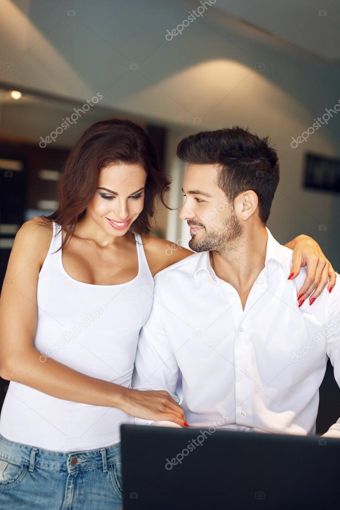 Young successful manager couple at home with laptop