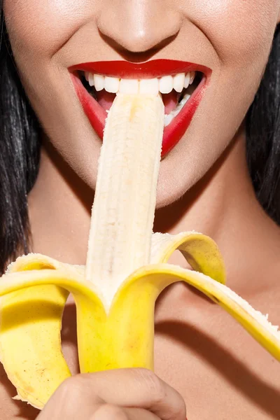 Mujer sexy con labios rojos comiendo plátano — Foto de Stock