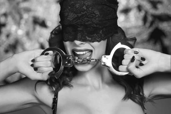 Сексуальний домінатрій тримає наручники чорно-білого кольору — стокове фото