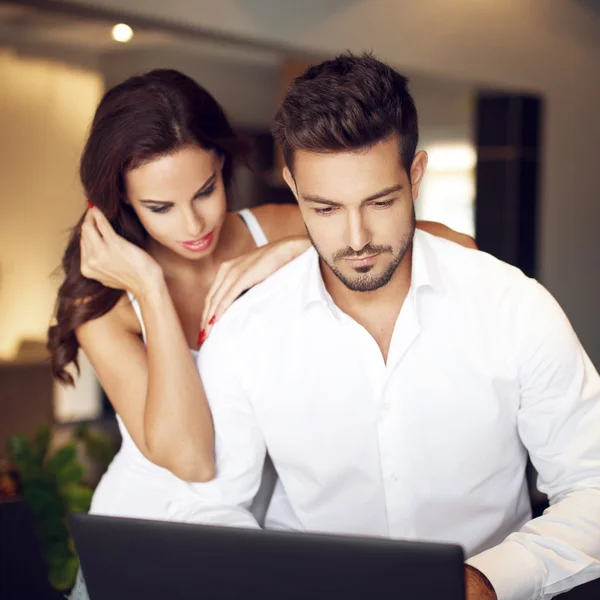 Casal jovem gerente comunicando on-line por laptop — Fotografia de Stock
