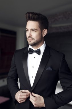 Sexy man celebrity in tuxedo indoor clipart