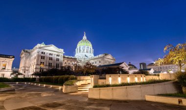 Pennsylvania Eyalet Meclisi, Harrisburg, Pennsylvania, ABD. Aydınlatılmış Beaux-Arts simgesi mavi saat boyunca modern peyzaj bahçesinden görülür.