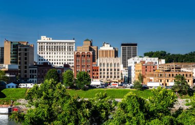 Charleston, Batı Virginia 'nın şehir merkezindeki gökyüzü açık ve güneşli bir günde Kanawha Nehri' nin karşısından izleniyor. Şehir manzarası nehir kıyısı boyunca tarihi ve modern mimariye sahiptir.