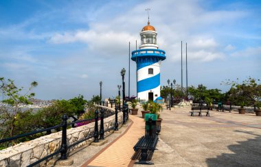 Ekvador, Guayaquil 'deki Santa Ana Tepesi' ndeki mavi ve beyaz deniz fenerinin manzarası. Bakış açısı, bulutlu mavi gökyüzünün altındaki şehre bakıyor.