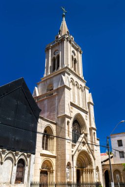 Valparaiso, Şili 'deki Kutsal Kalpler Kilisesi' nin Gotik Uyanış Kulesi 'nin dikey görüntüsü. Tarihi taş bina, Parque Italia yakınlarında derin mavi bir gökyüzüne karşı duruyor.