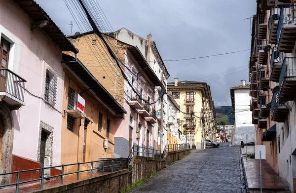 Ekvador Quito 'da renkli koloni evleriyle kaplı dik kaldırım taşı caddesi. Tarihi mimaride, Basilica yakınlarındaki UNESCO Dünya Mirası sahasında balkonlar ve pastel duvarlar yer alıyor.