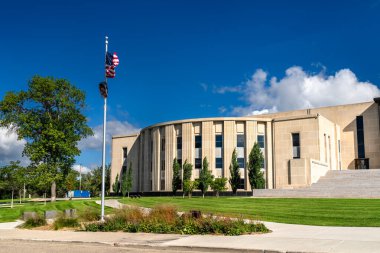 Kuzey Dakota Eyaleti Meclis Yasama Kanadı Bismarck, ABD 'de bulunmaktadır. Art Deco kireçtaşı binasında mavi gökyüzü altında kıvrımlı ön cephe ve Amerikan bayrağı yer alıyor