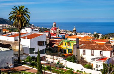 İspanya 'nın Kanarya Adaları' ndaki La Orotava ve La Concepcion Kilisesi 'nin tarihi manzarası. Renkli evler, palmiye ağaçları ve Atlantik Okyanusu.