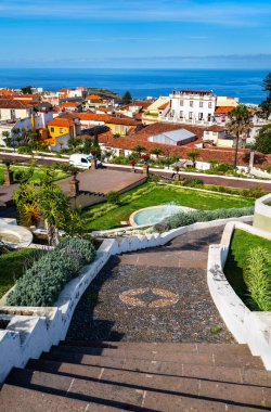 Tarihi Jardines Victoria 'nın taş merdivenlerinden aşağıya doğru güneşli manzara geleneksel La Orotava kasabasına ve Tenerife, Kanarya Adaları' ndaki okyanusa doğru bahçeler açtı..