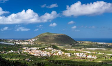 Montana de Taco volkanik konisinin manzarası yeşil muz çiftlikleri ve Tenerife, Kanarya Adaları 'ndaki okyanus kenarındaki geleneksel beyaz kasabalarla çevrili..
