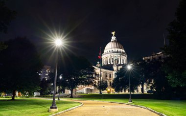 Jackson şehir merkezindeki kıvrımlı bir yoldan Mississippi Eyalet Kongre Binası 'nın aydınlatılmış kubbesi ve klasik cephesinin manzarası..