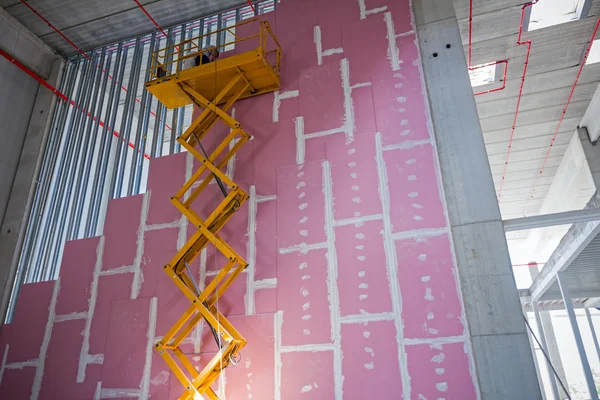 Plataforma elevadora de tijera en una obra de construcción . —  Fotos de Stock