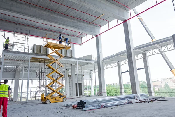 Plataforma elevadora de tijera en una obra de construcción . —  Fotos de Stock