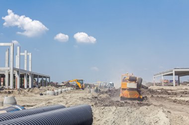 Sarı Mobil vinç inşaat sitesi üzerinden geçiyor.