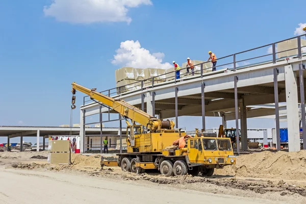 Mobile crane is raising package of glass wool on the roof huge u — Stock Photo, Image