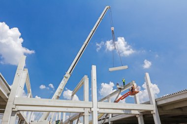Mobil vinç büyük salona beton kiriş taşıyor. 