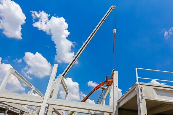 Mobil vinç büyük salona beton kiriş taşıyor. 