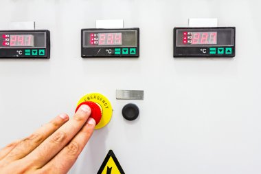 El, parmak acil Kırmızı Durdur düğmesini bastırıyor