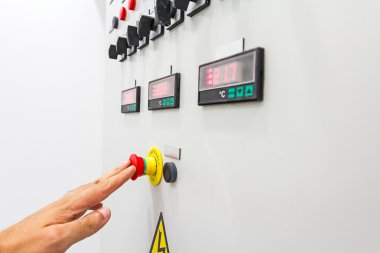 El, parmak acil Kırmızı Durdur düğmesini bastırıyor