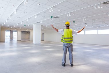 İşçi kask giyiyor ve yeni alışveriş merkezinde kutluyor