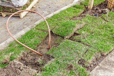 Copper pipe placed to the grass root clipart