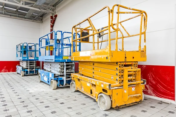 Cherry picker parked next to a newly metal building — Stock Photo, Image