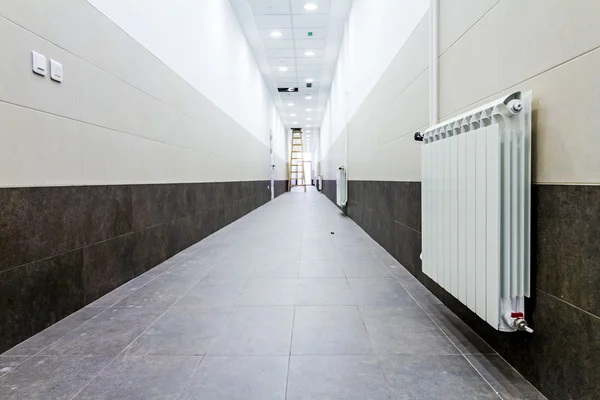 Verwarming van de radiator op de betegelde muur in de hal — Stockfoto