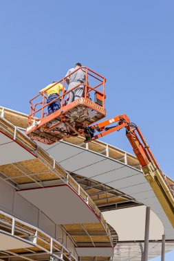 Height workers with help of cherry picker are working on new met clipart