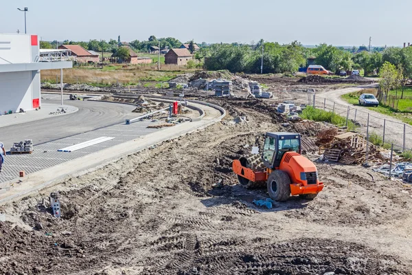 Величезний дорожній каток зі шипами ущільнює ґрунт при будівництві — стокове фото