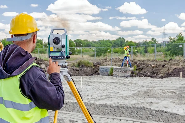 Geodesist bir inşaat alanı toplam istasyonu ile çalışıyor. Civi