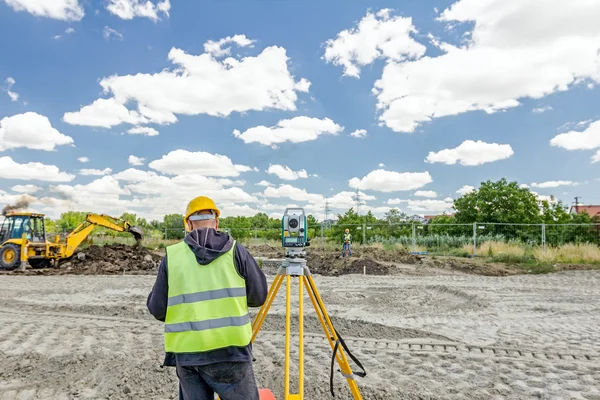 Geodesist está trabajando con la estación total en un sitio de construcción. Civi. — Foto de Stock