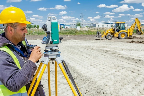 測地学者は建築敷地のトータル ステーションで働いています。Civi — ストック写真