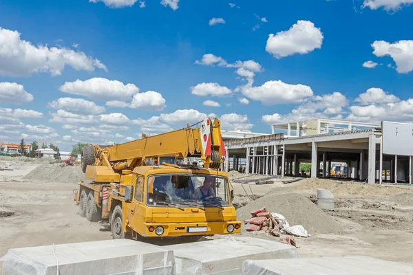 Sarı Mobil vinç inşaat sitesi üzerinden geçiyor.