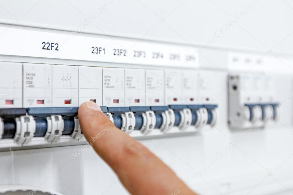 Hand is showing on electrical control panel electricity distribu