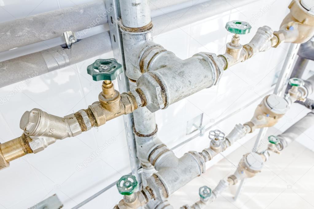 Room with lined up water meters, pipes and valves — Stock Photo