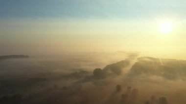 Yavaşça yukarıdan aşağıya doğru iniyor. Yavaşça süzülen buharı, ormanın buharını, şafak vakti manzarayı gösteriyor. Dolly aşağı iniyor..