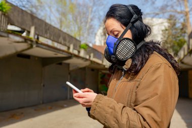 Kadın, COVID-19 virüsüne karşı korunmak için yüzünü kağıt filtreli endüstriyel maske takıyor.. 