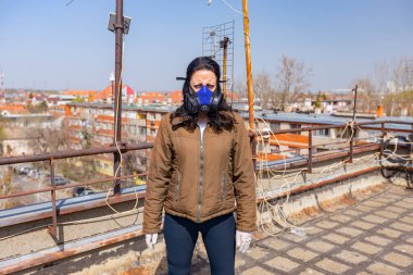 Kadın, COVID-19, Corona 'dan korunmak için kağıt filtresi ve eldiven takmış endüstriyel maske takıyor.. 