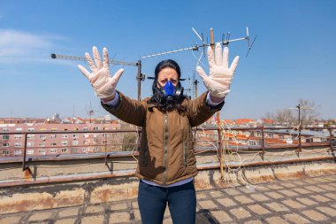 Medya baskısını durdurun. Endüstriyel maske takan kadının yüzünde kağıt filtre var. Elleri, hareketi, sosyal mesafesi, uzak durması, COVID-19 virüsüne karşı korunması, Corona.