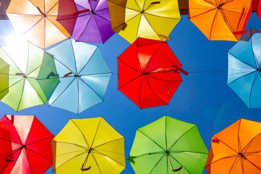 Renkli şemsiyeler asılıyor gökyüzünü şehir caddesine boyuyor, başımızı süpürüyor..