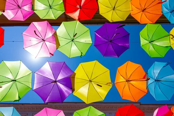 彩色雨伞挂在城市街道上方的天空上 扫过头顶 — 图库照片