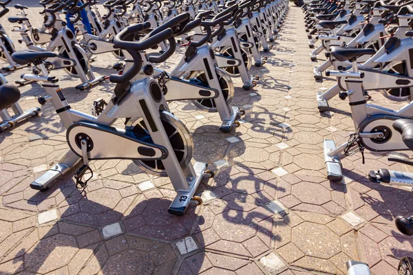 Group of indoor exercise bicycles are placed on the street ready for training.