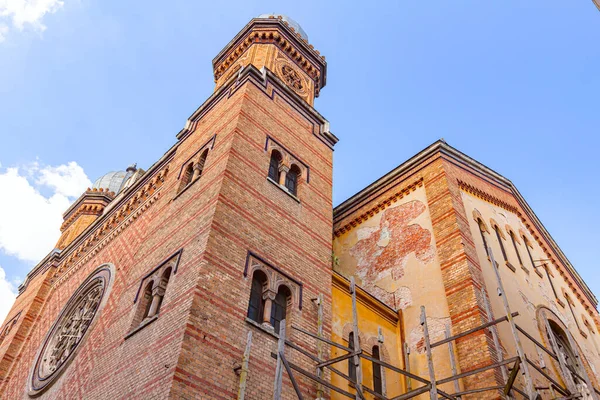 Side view on facade made of bricks with decorative texture, exterior of the Cetate Synagogue with scaffold in Timisoara, Romania. Renovation phase