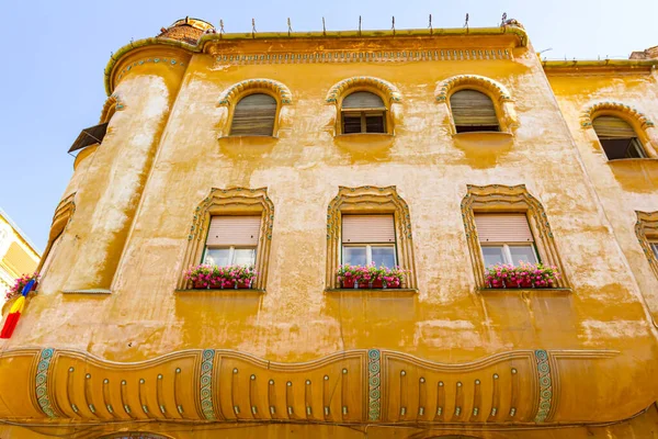 Dolny Widok Żółtą Ozdobioną Fasadę Doniczkami Ozdobnych Oknach Zewnątrz Starego — Zdjęcie stockowe