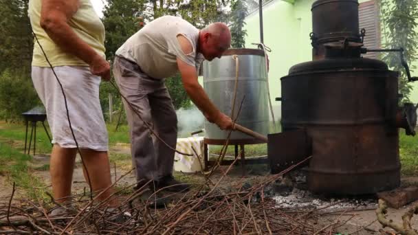 Çiftçi Damıtma Aparatının Altındaki Ateşten Közleri Çıkarıyor Yapımı Alkollü Içki — Stok video