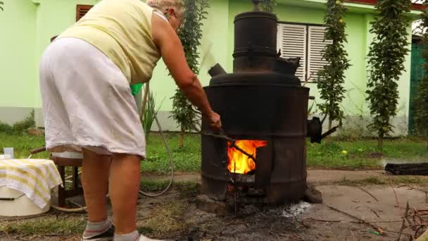 Babcia Jest Uspokoić Ogień Pod Aparaturą Destylacyjną Produkcji Alkoholu Domowego — Wideo stockowe