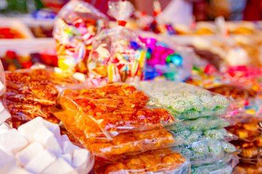 Bit pazarında satılık çeşitli renkli şeker ve tatlılar tepsilere konur..